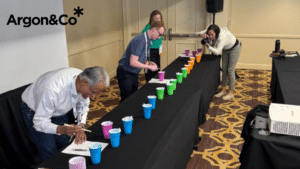 Serial Picking vs Bucket Brigade simulation at a table with three people and solo cups.