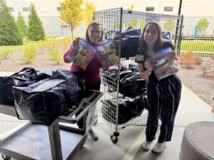 Two young women at Children's Healthcare of Atlanta accepting kits at Authur M Blank Hospital for kids, caregivers and staff.